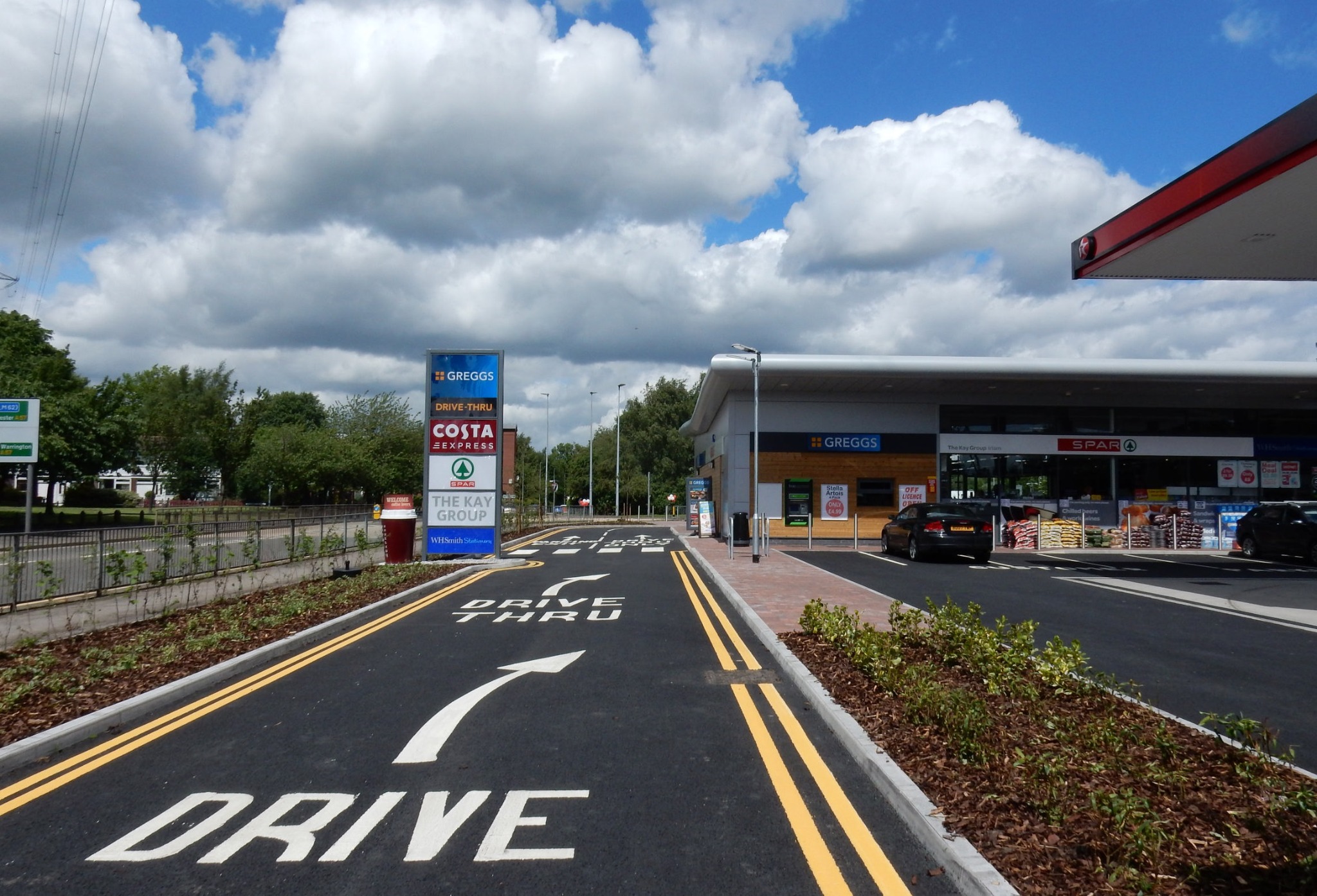 Drive-thru lane and roadside retail signage at Irlam Gateway Service Station
